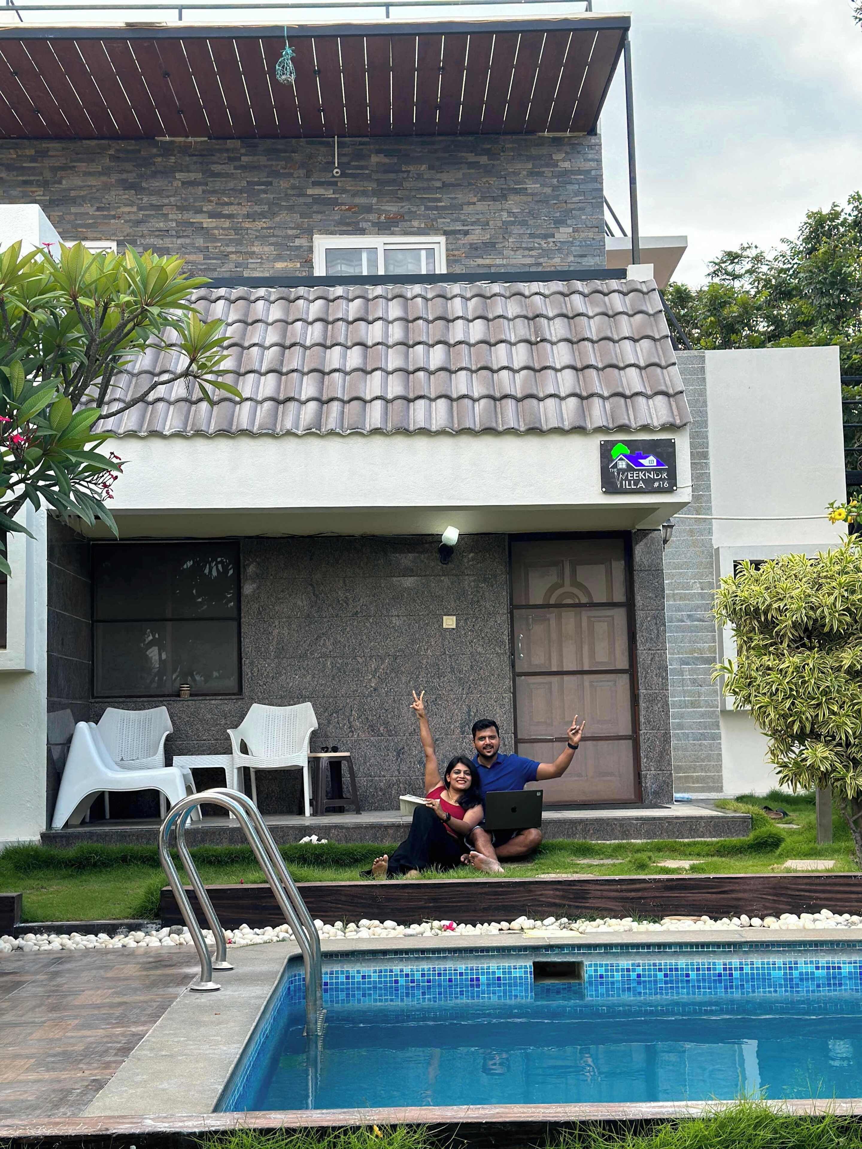 A villa with a swimming pool, outdoor seating, and a stone facade.