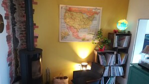 Una stanza accogliente con una mappa, una libreria, un globo e un camino.