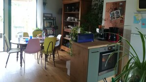 Una cucina con mobili in legno, un tavolo da pranzo con sedie, una macchina da caffè e un frigorifero.