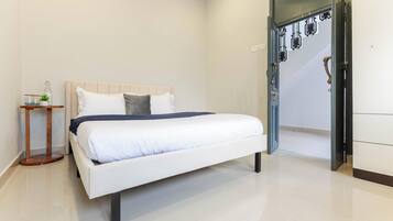 A bedroom with a bed, bedside table, and a wardrobe.
