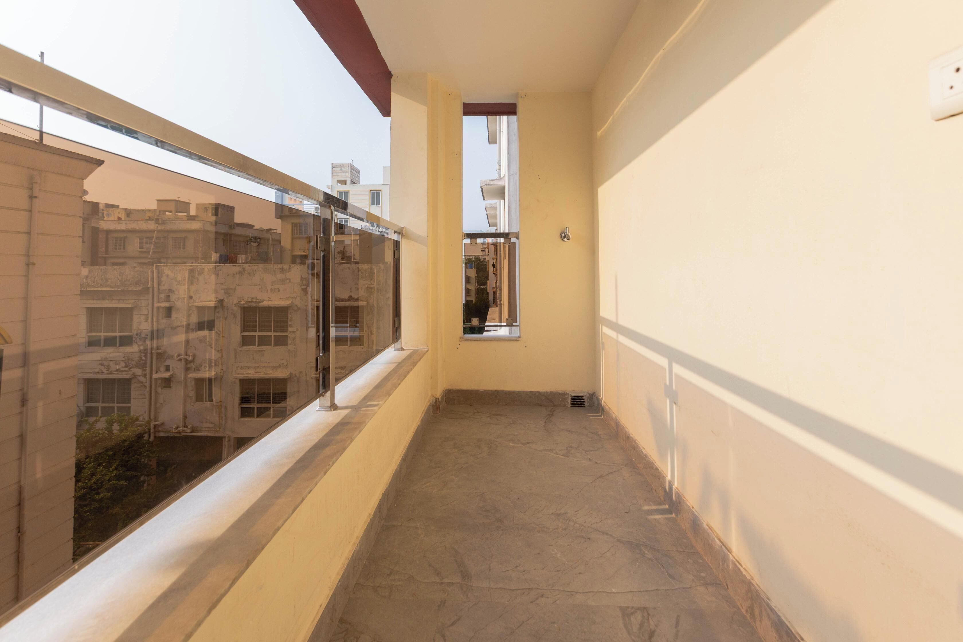 A narrow corridor with a window on the left and a door at the end.