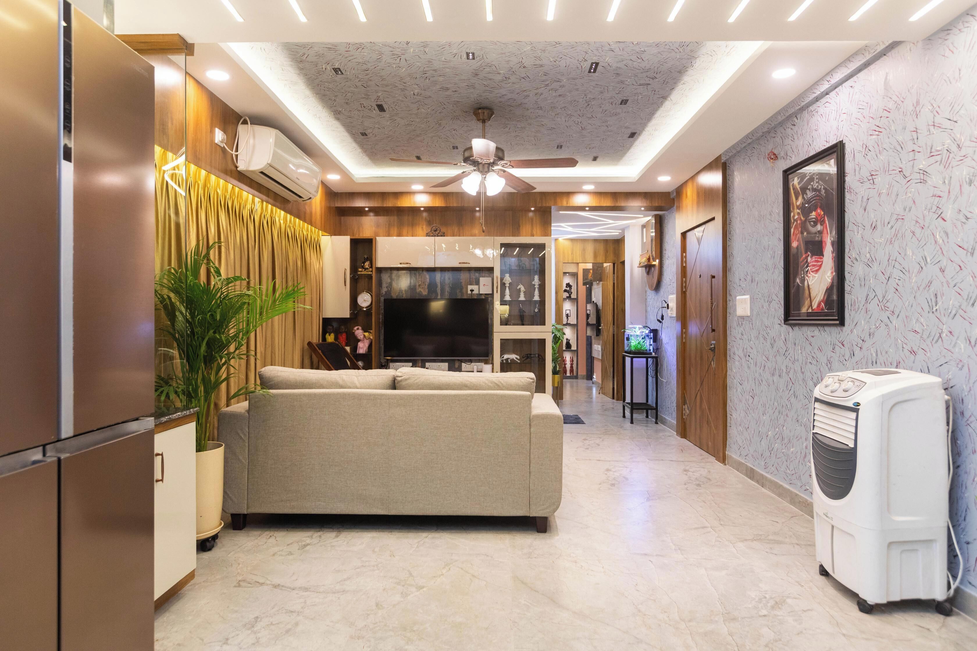 A modern living room with a sofa, TV, ceiling fan, and air conditioning unit.