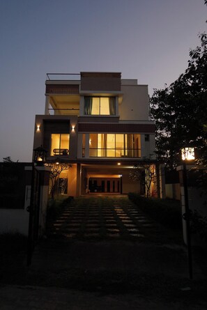 A modern two-story house with a front entrance, a staircase, and a well-lit interior. - Aurora Mansion by Red Olive 3bhk Nr ECR Beach (Chennai)