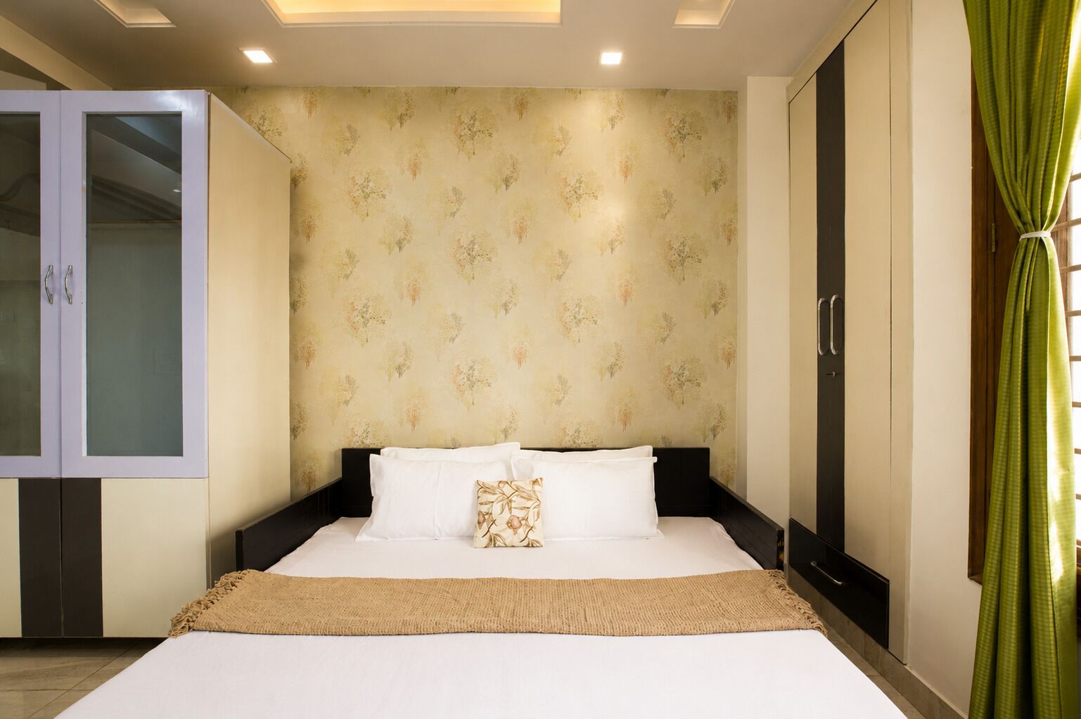 A bedroom with a bed, a wardrobe, and a curtain.