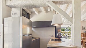 A modern kitchen with a built-in refrigerator, a microwave, and a coffee machine. - Stone house for 5, garden, beach 700m away (Sarzeau)