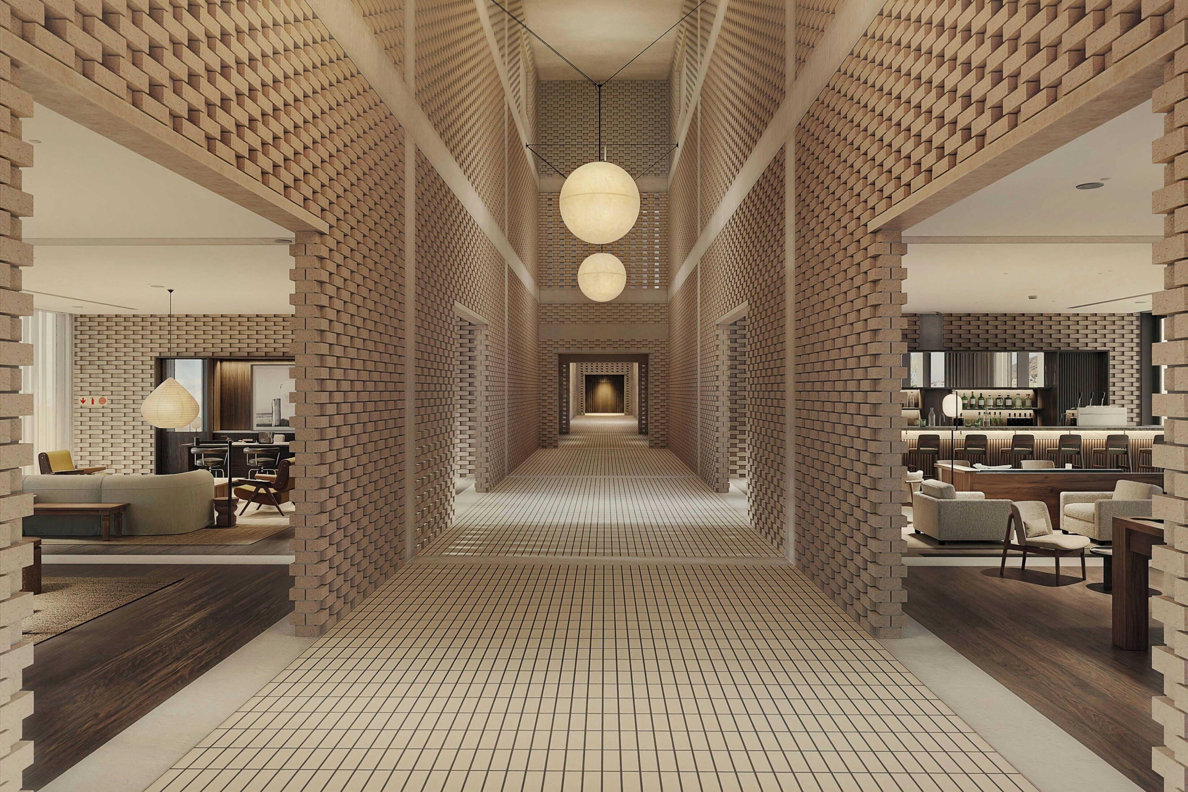 Un intérieur moderne avec un mur décoré d’un motif en briques, un luminaire central et un coin bar.