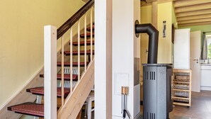 Eine Treppe mit roten Teppichstufen, einem Holzgeländer und einer weißen Wand.