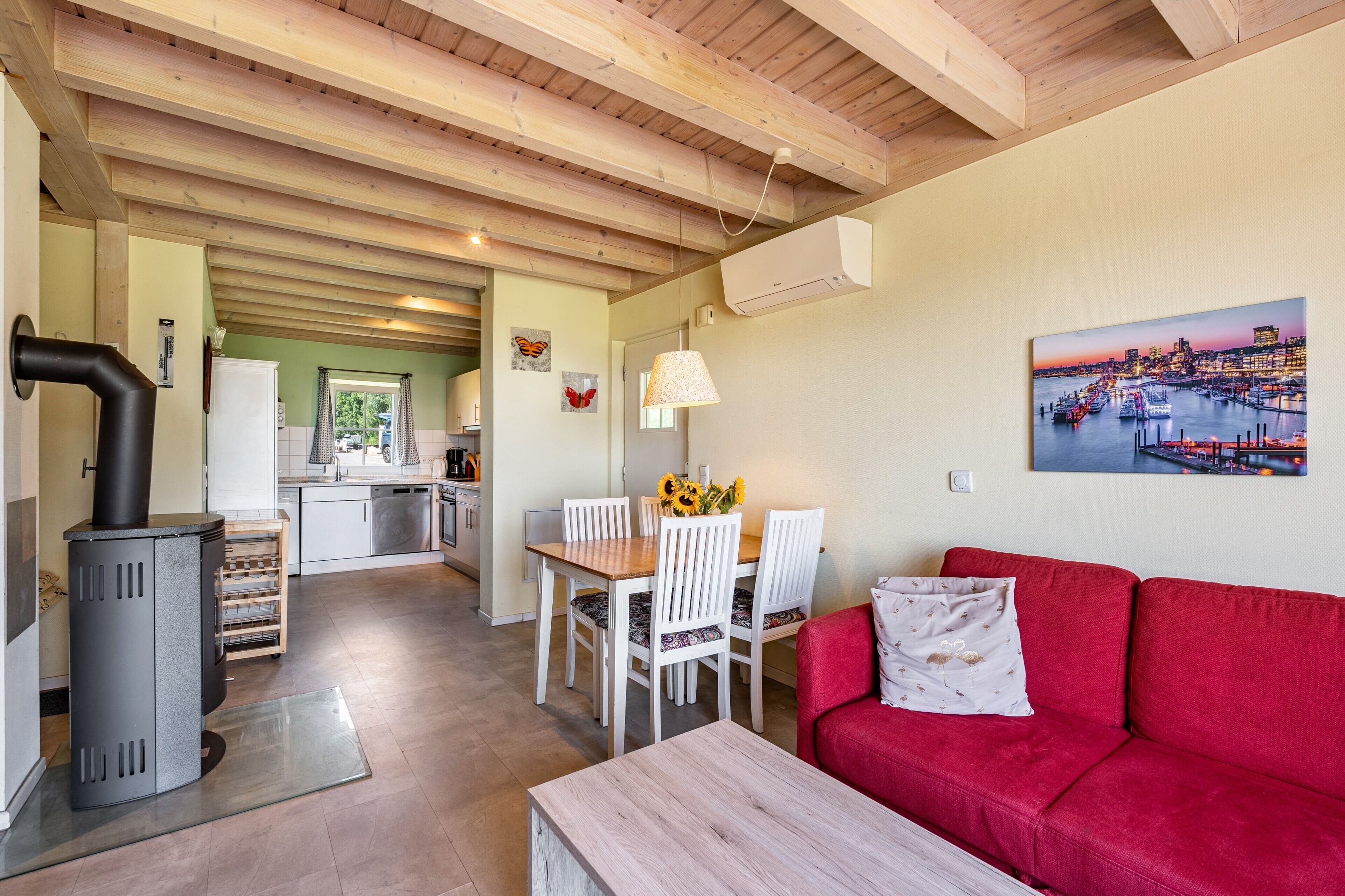 Un espacio habitable compacto con cocina, comedor y un sofá rojo.