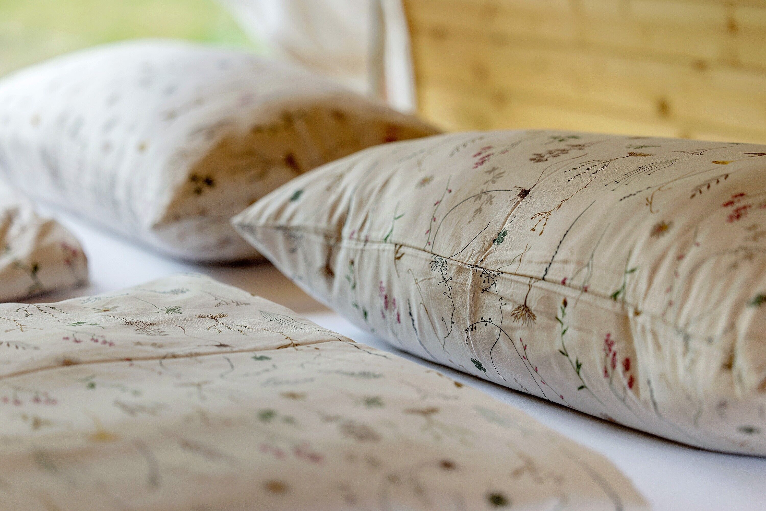 Almohadas con motivos florales sobre una cama.