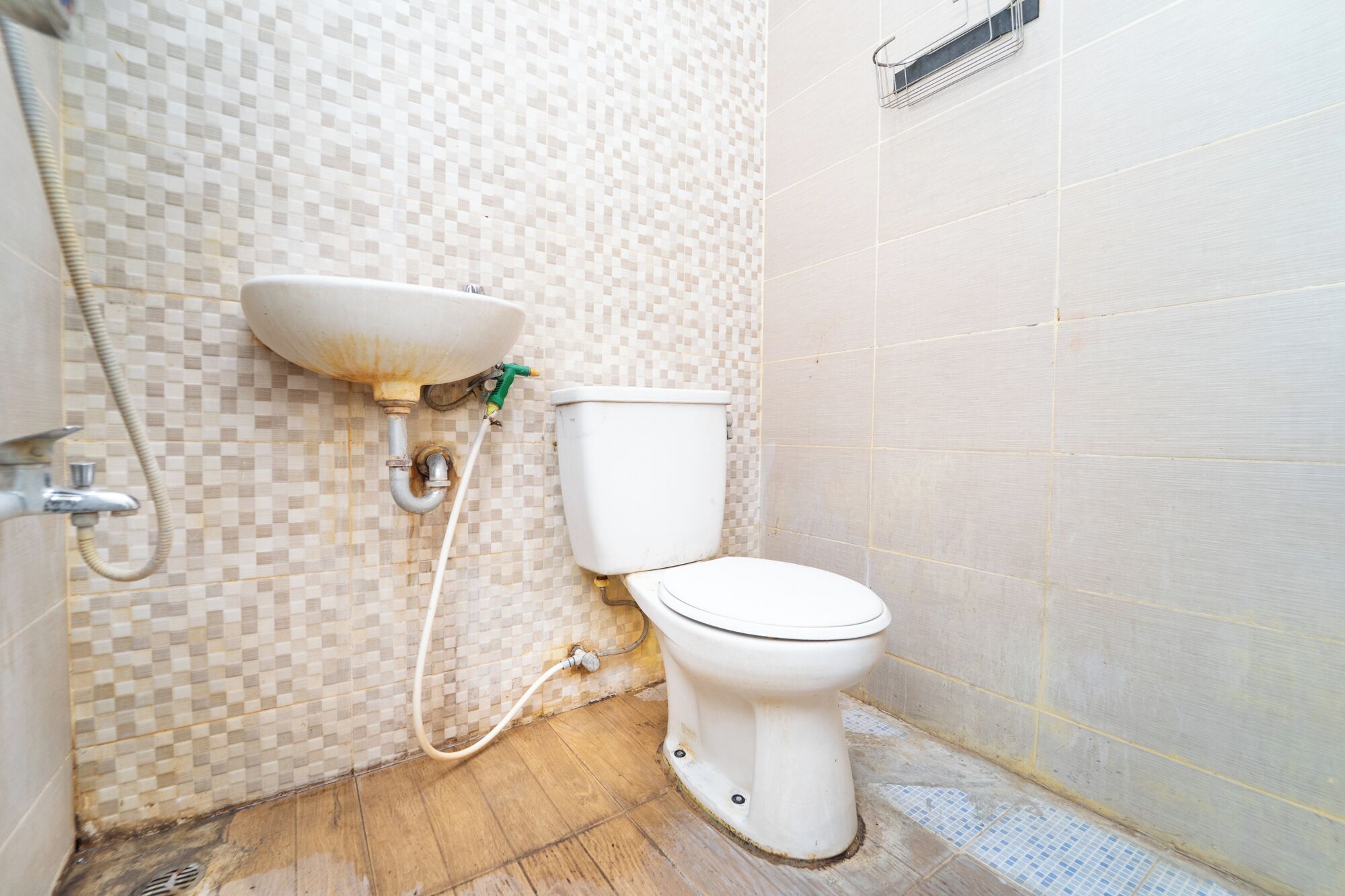 Une salle de bain avec un mur carrelé, un lavabo et des toilettes.