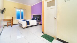 A bedroom with a bed, a desk, and a chair. - Sunrise 888 By ARBA (Semarang)