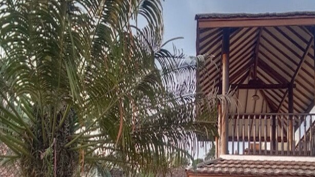 A building with a sign reading 'VILLAPANGI,' a covered outdoor area with a railing, and a parked car. - Cozzy Villa Pangi (Bandung)
