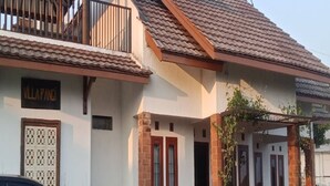 A two-story building with a tiled roof, a balcony with a railing, and a sign that reads 'VILLAPANGI'. - Cozzy Villa Pangi (Bandung)