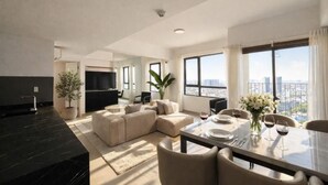 Un salon moderne avec un canapé, une table à manger et de grandes fenêtres donnant sur la ville.