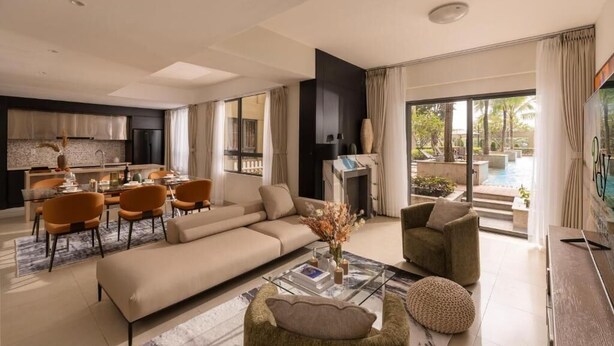 Un salon moderne avec un canapé, des fauteuils, une table basse et une cheminée.
