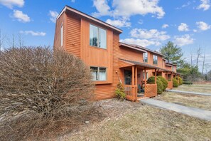 A two-story wooden house with a porch and a small front yard. - Indoor Pool + Sauna | Gore Mtn + North Creek | The Summit at Gore Mountain (North Creek)