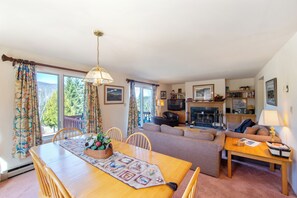 Ein gemütliches Wohnzimmer mit Esstisch, Sofas und Kamin.