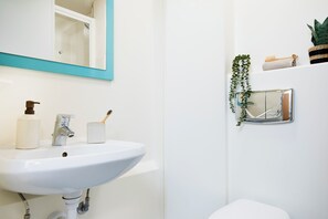 A bathroom with a white sink, mirror, and toilet. - Student Only - Ty Pont Haearn - Cardiff (Cardiff)