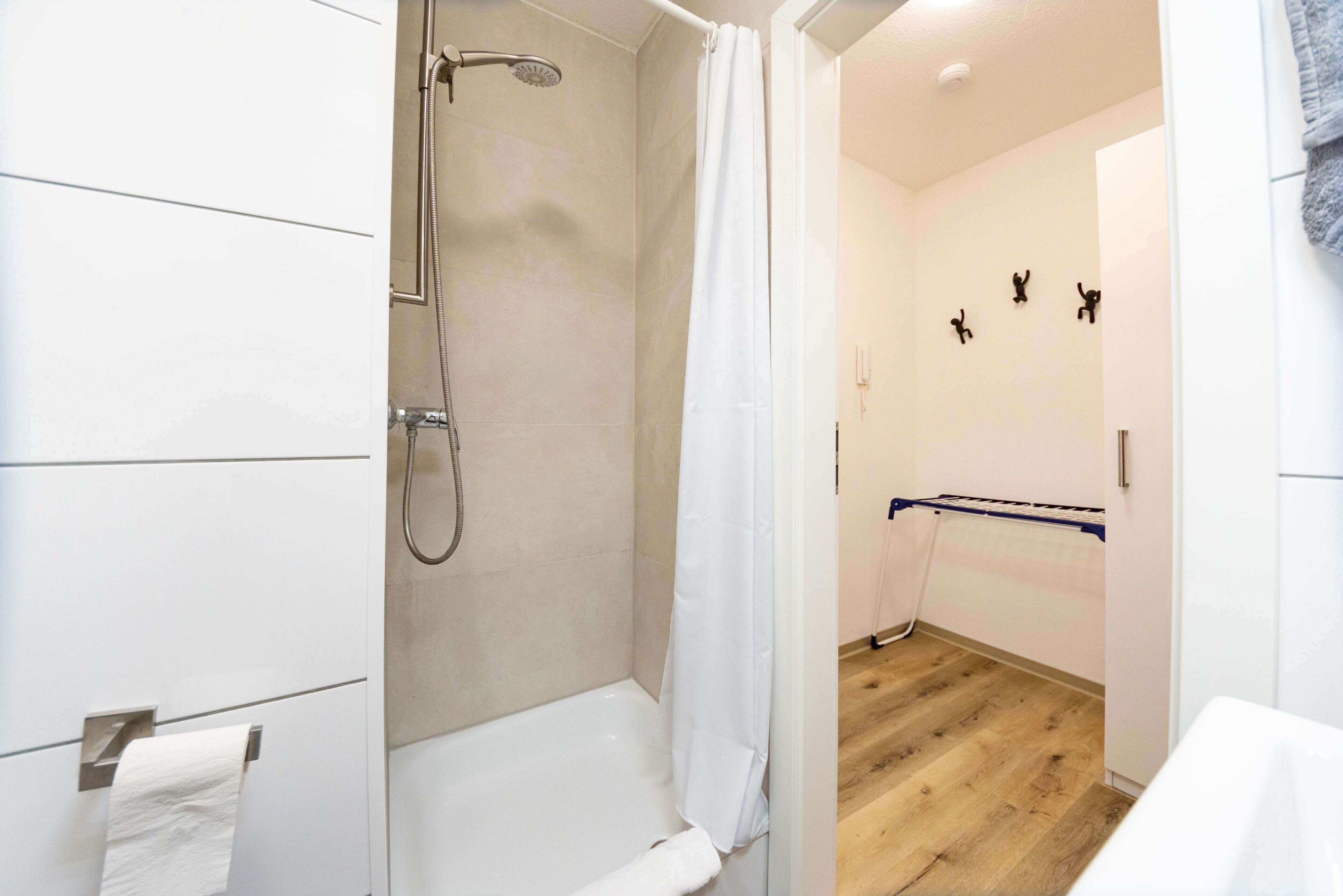 Un baño moderno con ducha, inodoro y perchero para toallas.