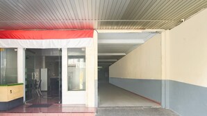A building entrance with a security desk, a glass door, and a tiled floor. - Cozy Double Escape W/ Free Wifi and Parking (Makassar)