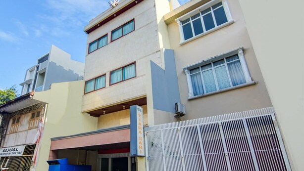 A multi-story hotel with a flat facade, large windows, and a gated entrance. - Cozy Double Escape W/ Free Wifi and Parking (Makassar)