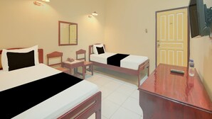A hotel room with two beds, a desk, a chair, a TV, and a door. - Cozy Double Escape W/ Free Wifi and Parking (Makassar)