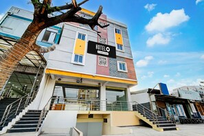 A multi-story hotel with a sign reading 'HOTELO & Company Services.' - Hotel O Hafizpet Railway Station (Hyderabad)