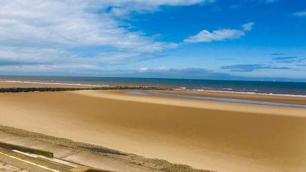 A beach with a clear sky and calm sea. - Sandy Beach Retreat (Prestatyn)