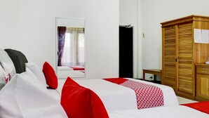 A hotel room with a bed, a wardrobe, a mirror, and a window with curtains. - Nascar Family Cozy Twin Stay (Palangkaraya)