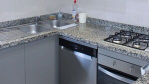 A kitchen with granite countertops, stainless steel appliances, and wooden cabinetry.