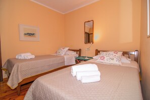 Ein Hotelzimmer mit zwei Betten, einem Nachttisch, einem Spiegel und einem gerahmten Bild an der Wand.