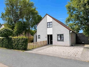 A single-story house with a sloped roof, a front door, and a small window on the side.