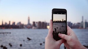 A smartphone displaying a city skyline with water in the foreground.