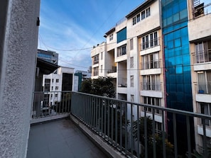 Un edificio residencial con varios balcones, cielo despejado y una línea eléctrica visible.