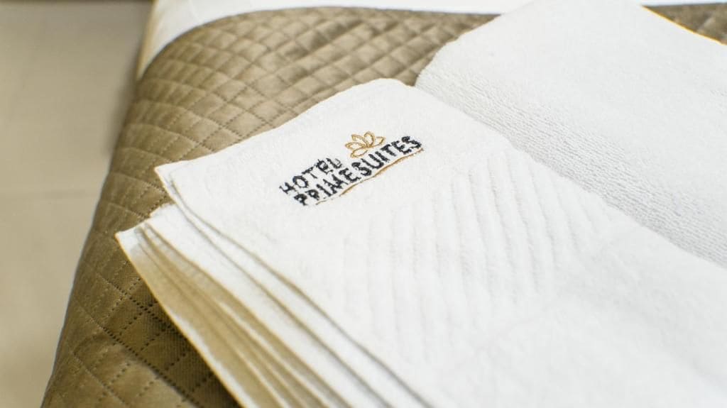 A stack of white towels with a logo on them.