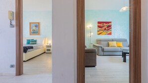 Een woonkamer met een bank, een bijzettafeltje en een schilderij aan de muur.