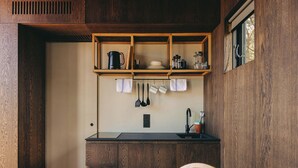 Uma cozinha compacta com armários de madeira, bancada preta e janela com vista.