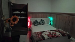 Une chambre à coucher avec un lit, une armoire et une table de chevet.
