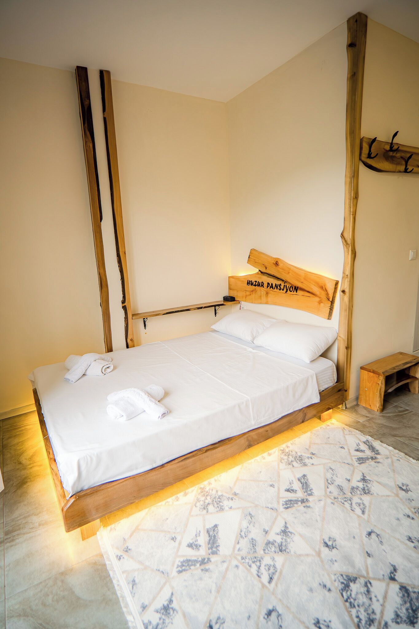A bed with a wooden headboard, a bedside table, and a bench.