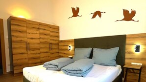 Ein Schlafzimmer mit Bett, Holzschrank, Wandleuchten und Wanddekoration.