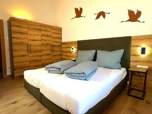 Ein Schlafzimmer mit Bett, Holzschrank, Wandleuchten und Wanddekoration.
