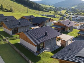 A residential area with modern houses featuring sloped roofs, wooden exteriors, and a well-maintained lawn. - Ski-in/ski-out Chalet With Beautiful View (Sankt Lambrecht)