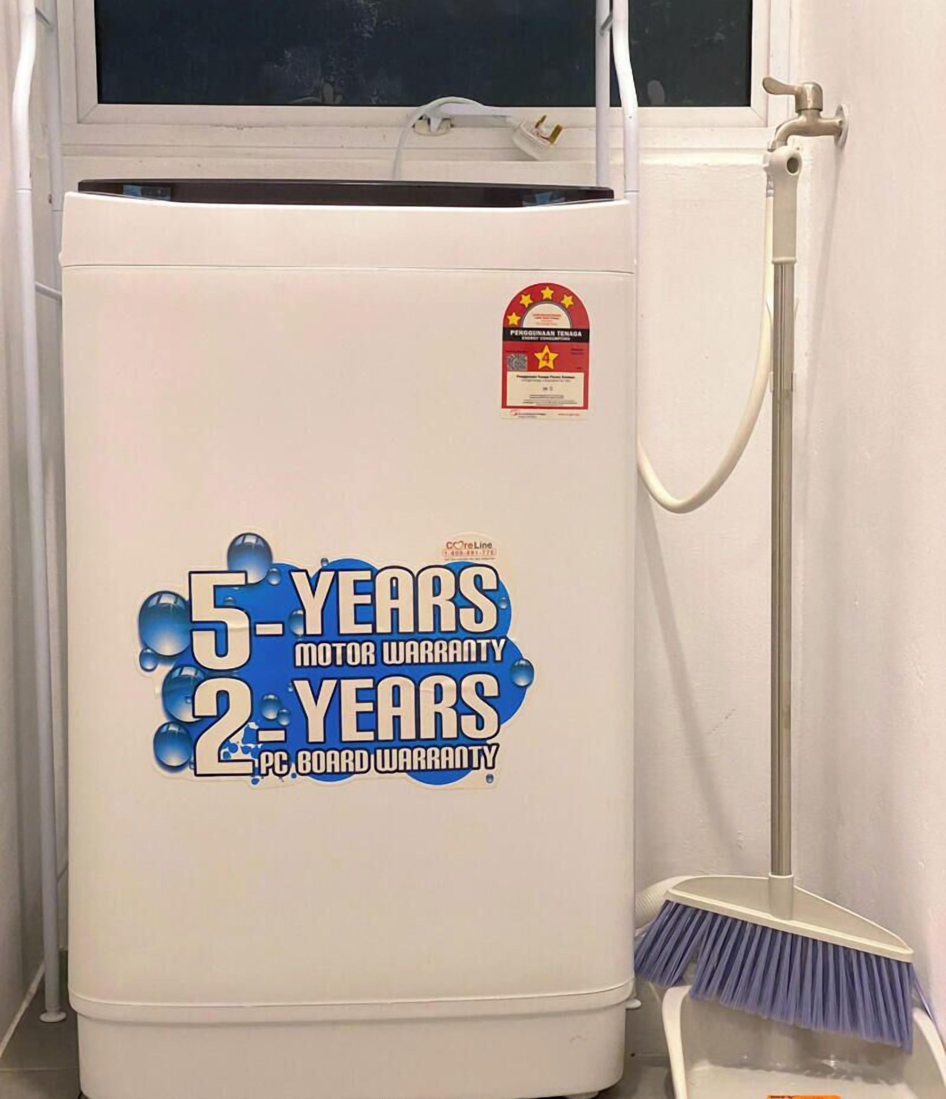 A white appliance with a sticker indicating a 5-year motor and 2-year PC board warranty.