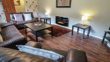 A living room with a sofa, coffee table, and TV stand.