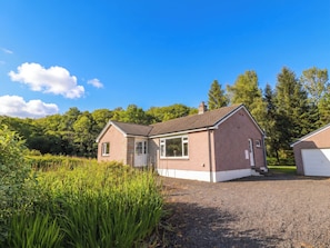 Ein zweistöckiges Haus mit Veranda, Garage und Auffahrt.
