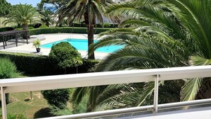 A pool surrounded by palm trees and a clear blue sky. - St Cyprien, a sunny interlude by the water (Saint-Cyprien)