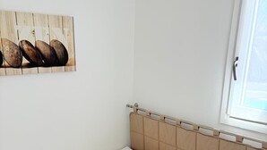 A single bed with a headboard, a window with a view, and a wall-mounted picture. - St Cyprien, a sunny interlude by the water (Saint-Cyprien)