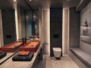 Ein modernes Badezimmer mit einem großen Spiegel, zwei Waschbecken, einer Toilette und einer Sitzbank.