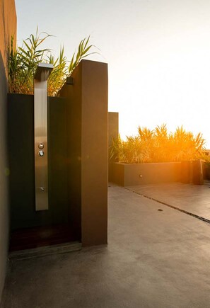 Entrada de um edifício moderno com piso de concreto e porta de metal.