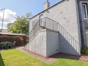 A concrete staircase leading to a building entrance, a wooden fence, and a green lawn. - 2 St. Catherines Cottages (Perth)